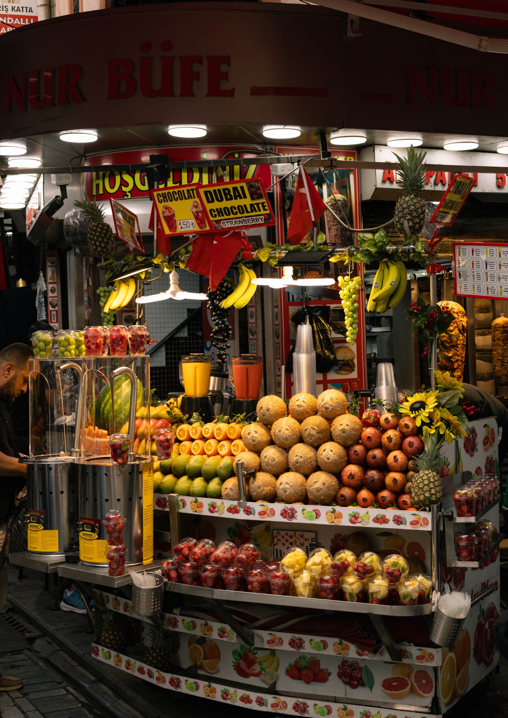 Uma banca de fruta e sumos iluminada à noite, Istambul