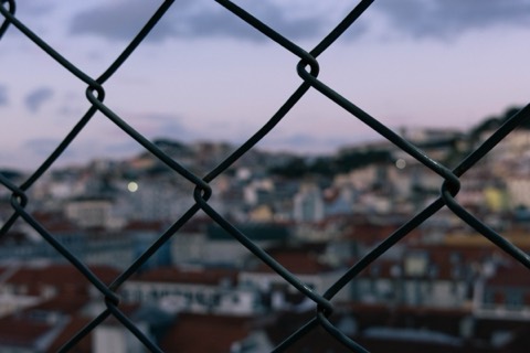 Telhados de Lisboa vistos através de uma rede ao entardecer