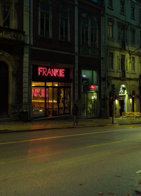 O letreiro de néon do bar Frankie numa rua vazia, Coimbra