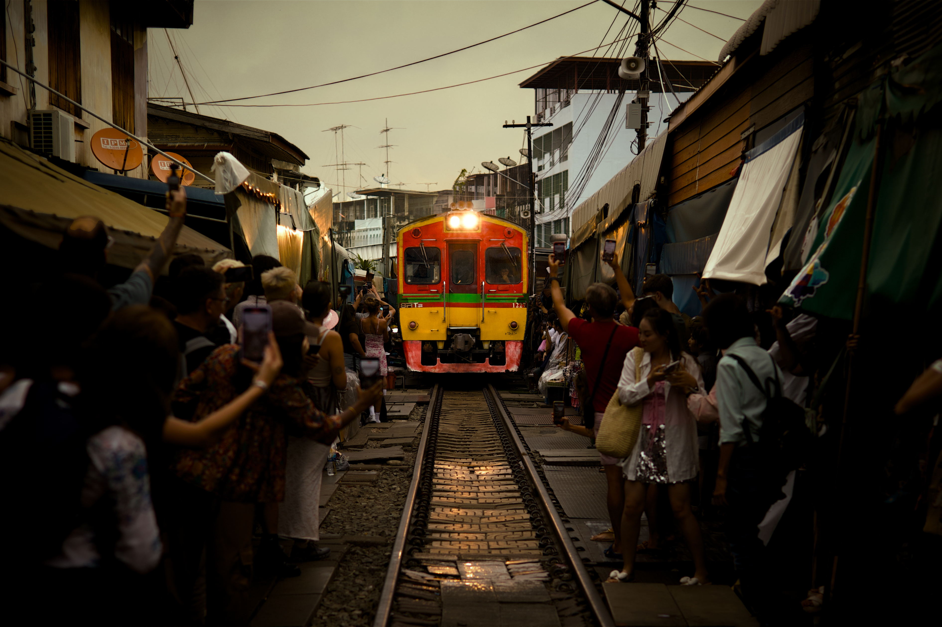 Train through Maeklong market at dusk